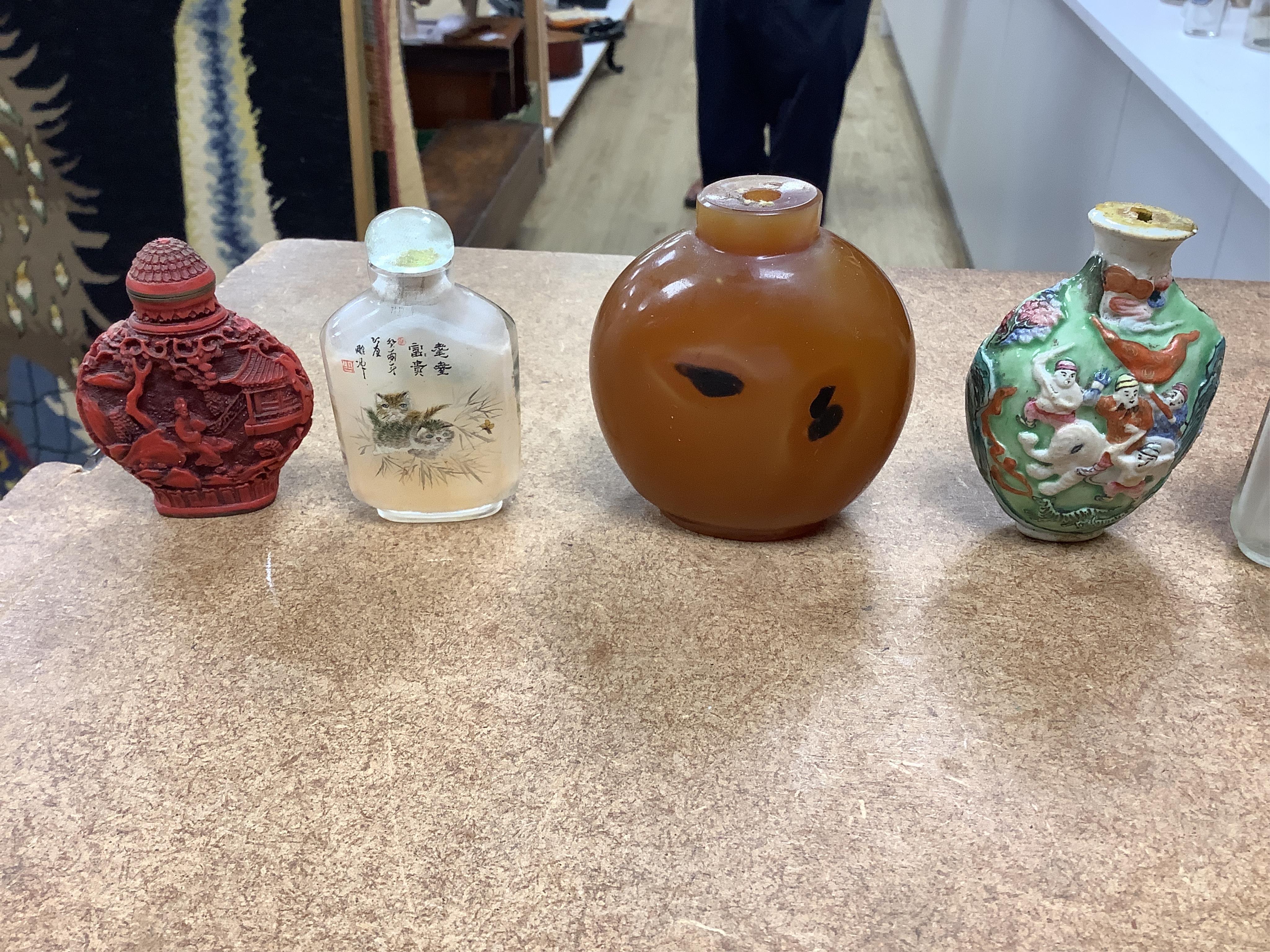 A small collection of Chinese snuff bottles, 19th century and later to include reverse glass painted examples and cinnabar lacquered examples, largest 9.5cm high